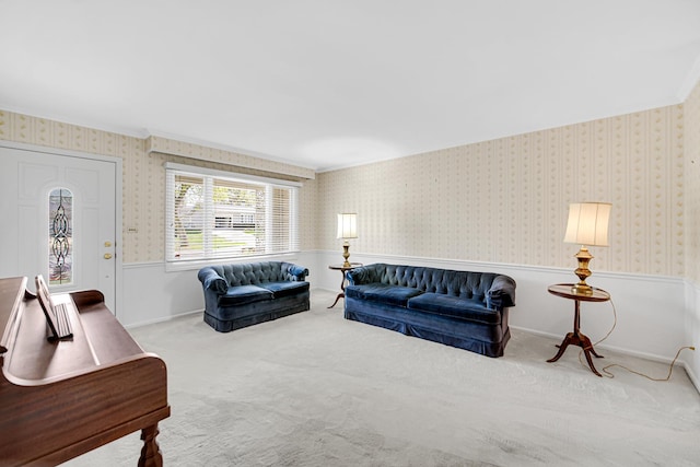 carpeted living room with wainscoting, wallpapered walls, and crown molding