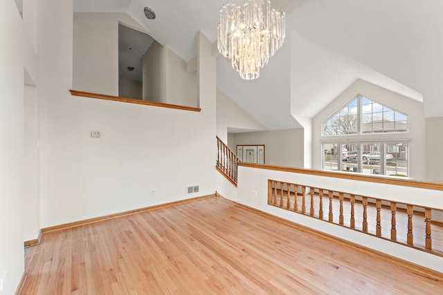 18020 Charlotte Dr, Lansing, IL 60438 - additional living space with baseboards, an inviting chandelier, visible vents, high vaulted ceiling, and wood finished floors