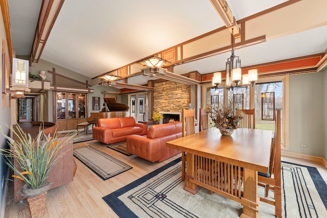 8712 W 121st St, Palos Park, IL 60464 - dining room with a chandelier, light wood finished floors, beamed ceiling, a stone fireplace, and high vaulted ceiling
