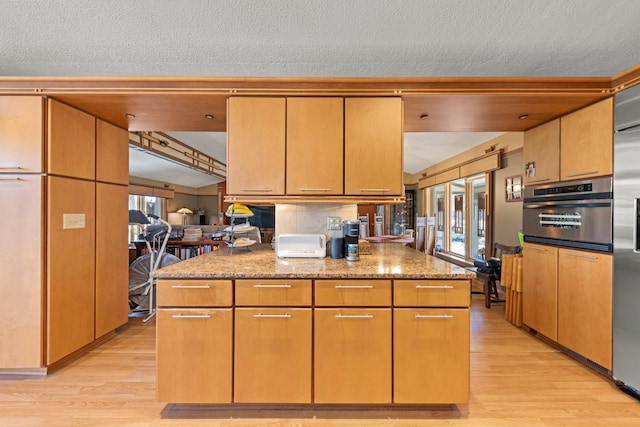 8712 W 121st St, Palos Park, IL 60464 - kitchen with light wood-style floors, oven, light stone counters, and a textured ceiling