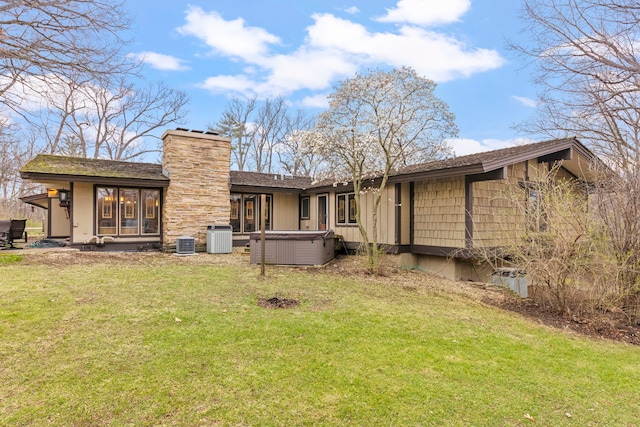 8712 W 121st St, Palos Park, IL 60464 - back of property featuring a hot tub, a lawn, a chimney, and central AC unit