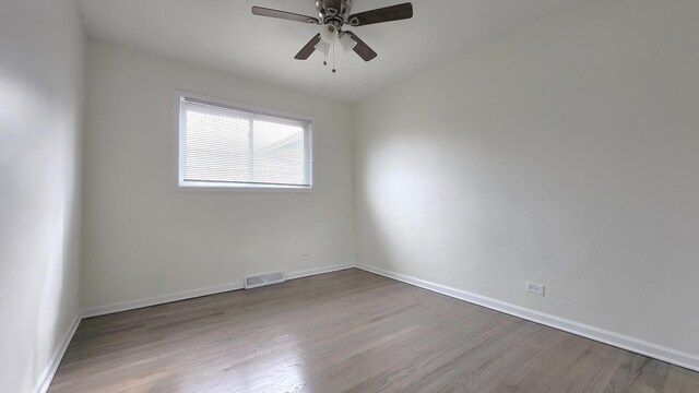 spare room with visible vents, baseboards, a ceiling fan, and wood finished floors