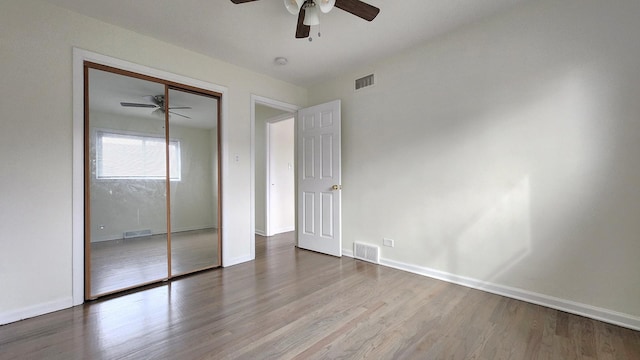 unfurnished bedroom featuring visible vents, baseboards, and wood finished floors