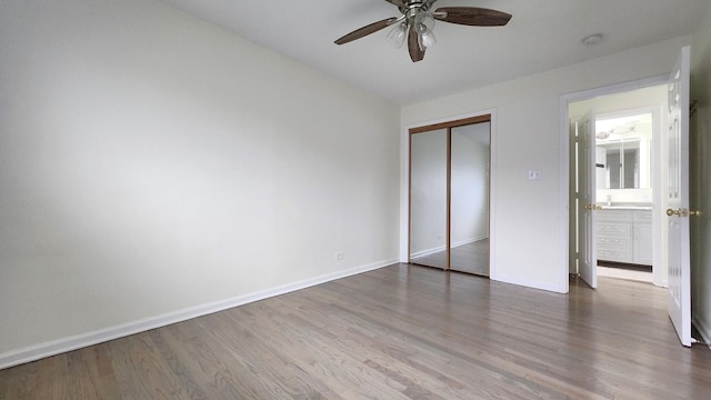 unfurnished bedroom with wood finished floors, ceiling fan, a closet, and baseboards