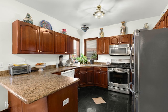 kitchen with a peninsula, a sink, granite finish floor, stainless steel appliances, and a toaster