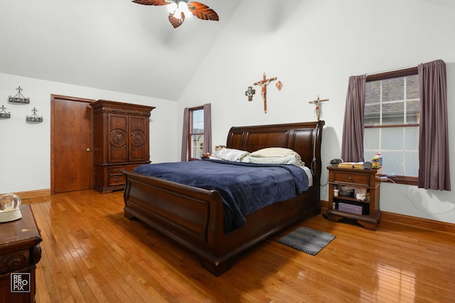 bedroom featuring high vaulted ceiling, light wood-style flooring, baseboards, and ceiling fan