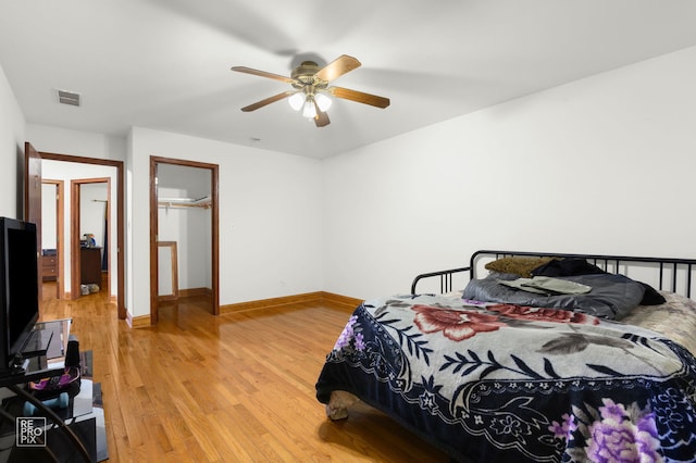 bedroom with light wood-style flooring, baseboards, visible vents, and a ceiling fan