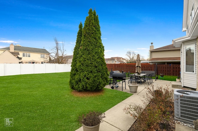 view of yard featuring central AC unit, a fenced backyard, and a patio area