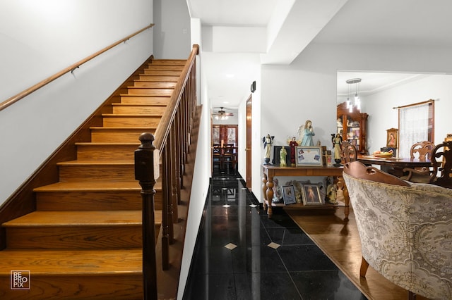 stairway featuring ceiling fan