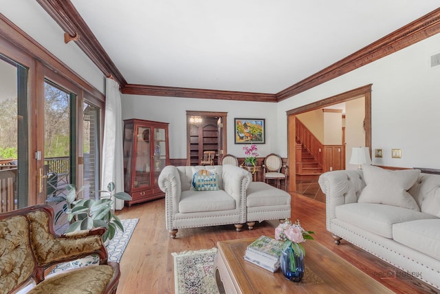 living area with stairway, wood finished floors, and crown molding
