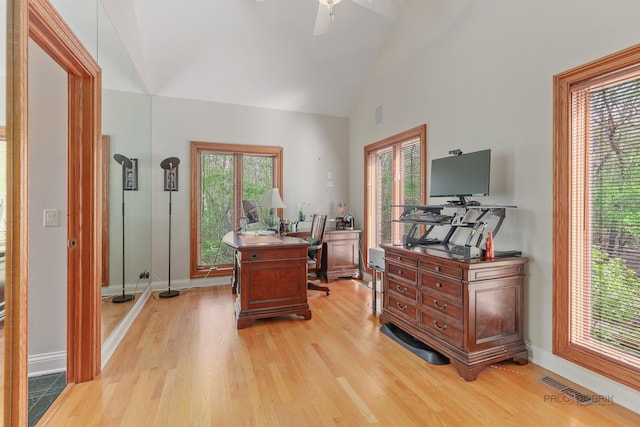 office space featuring light wood-style floors, baseboards, high vaulted ceiling, and ceiling fan