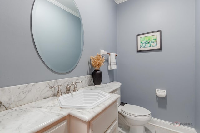 bathroom with crown molding, vanity, toilet, tile patterned flooring, and baseboards