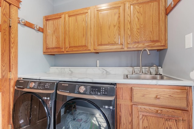 clothes washing area with cabinet space and washer and dryer