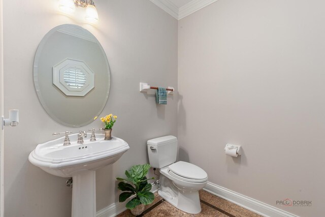 half bathroom featuring baseboards, ornamental molding, and toilet