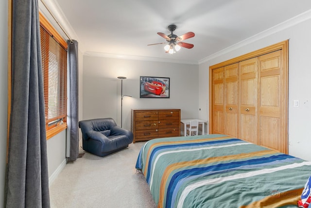 bedroom featuring carpet flooring, crown molding, a closet, baseboards, and a ceiling fan