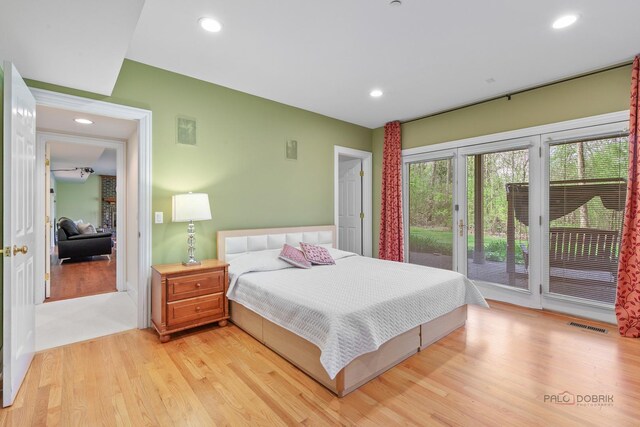 bedroom with access to exterior, light wood-style floors, and recessed lighting