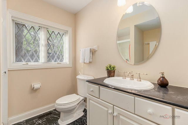 bathroom featuring marble finish floors, toilet, baseboards, and vanity
