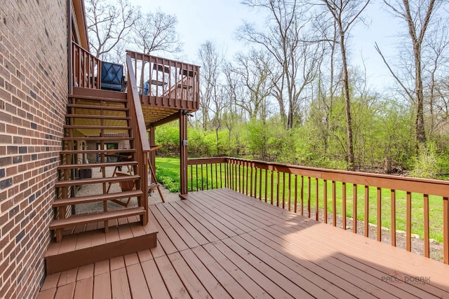 wooden deck featuring stairway and a lawn