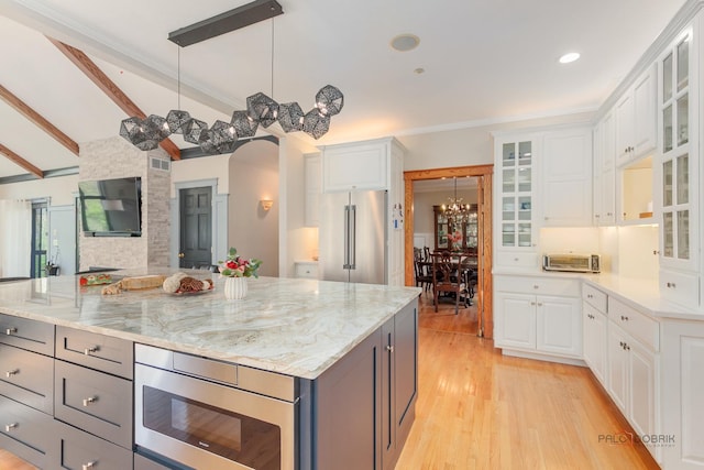 kitchen with appliances with stainless steel finishes, white cabinets, light wood-style flooring, beamed ceiling, and recessed lighting