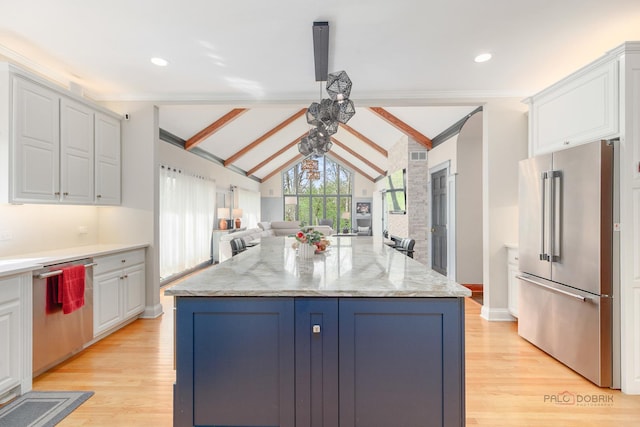 kitchen with appliances with stainless steel finishes, white cabinetry, open floor plan, light wood-type flooring, and crown molding