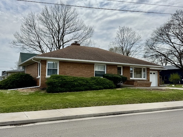 1002 7th St, Peru, IL 61354 - view of front of property with a front yard, an attached garage, brick siding, and roof with shingles