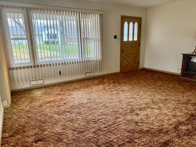 1002 7th St, Peru, IL 61354 - unfurnished living room featuring baseboards and carpet flooring