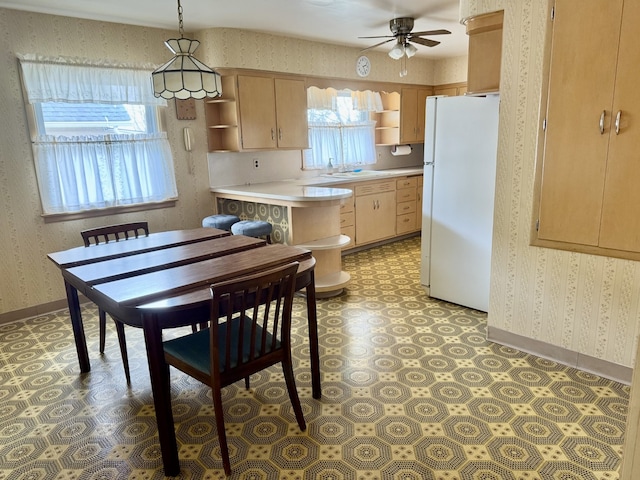 1002 7th St, Peru, IL 61354 - kitchen with wallpapered walls, freestanding refrigerator, open shelves, and ceiling fan