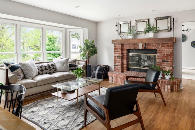 living area featuring a brick fireplace and wood finished floors