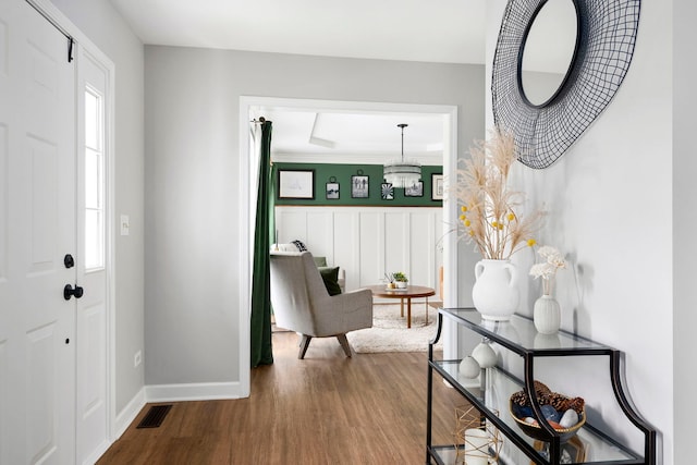 foyer with visible vents, baseboards, and wood finished floors