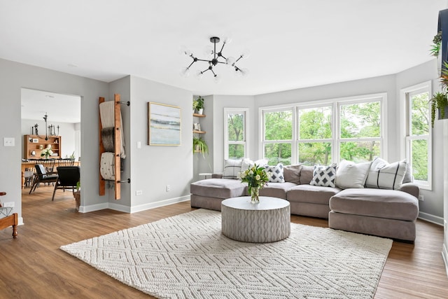 living room with baseboards, a chandelier, and wood finished floors