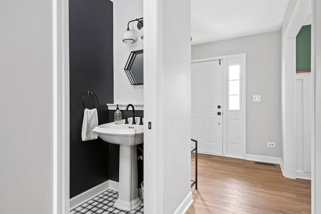 bathroom featuring baseboards, wood finished floors, and visible vents