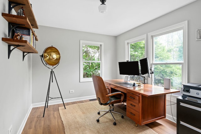 office area with baseboards and light wood finished floors