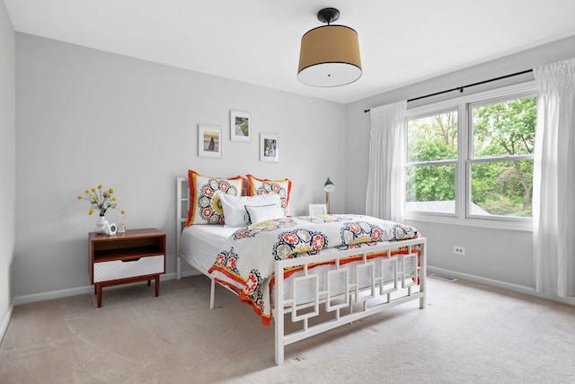 carpeted bedroom with baseboards and visible vents