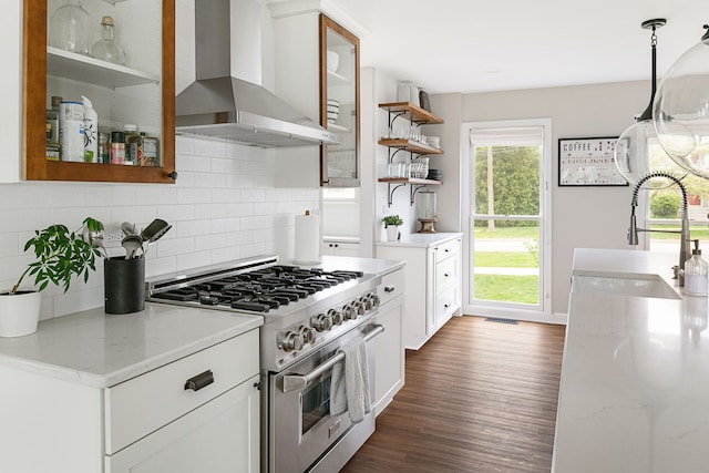 kitchen with tasteful backsplash, open shelves, a sink, high end stainless steel range, and wall chimney exhaust hood