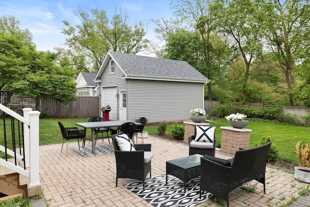 view of patio / terrace with an outdoor structure, a fenced backyard, a garage, and outdoor dining area
