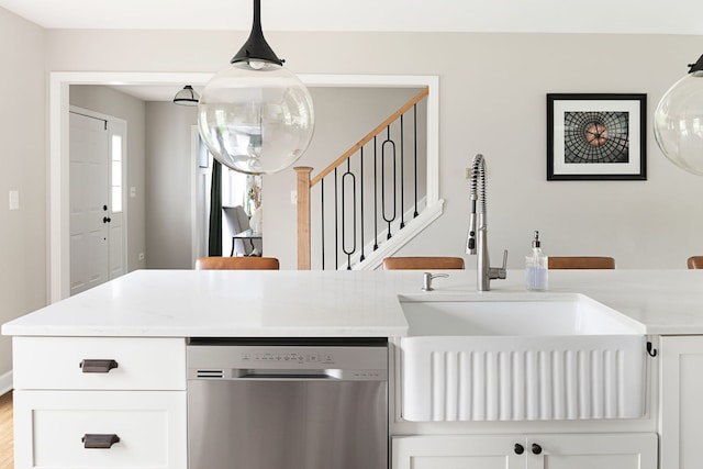 interior space featuring a sink, white cabinets, and stainless steel dishwasher
