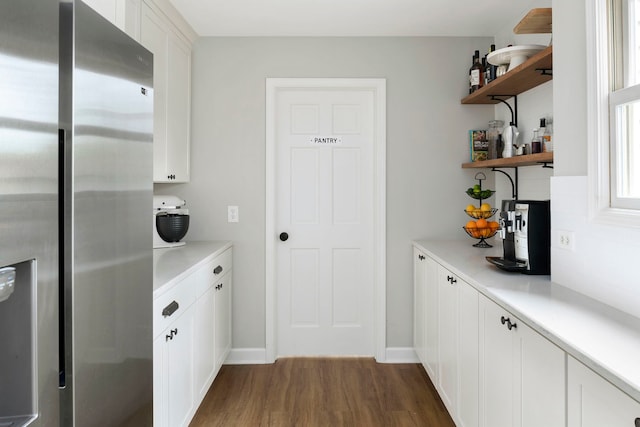 kitchen with light countertops, stainless steel fridge with ice dispenser, open shelves, and dark wood-type flooring