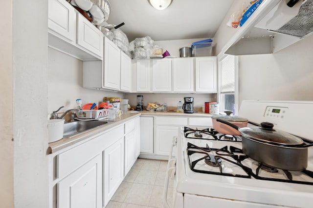 123 Philippa Ave, Waukegan, IL 60085 - kitchen with white gas range, a sink, light countertops, white cabinets, and under cabinet range hood