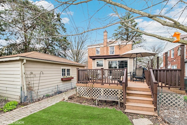 rear view of house with an outdoor structure and a wooden deck
