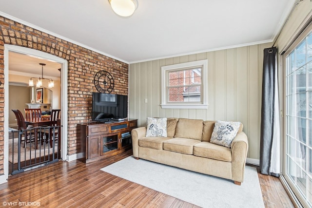 living room featuring crown molding and a healthy amount of sunlight