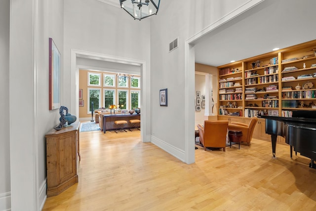 8673 Timber Ridge Dr, Burr Ridge, IL 60527 - sitting room with light wood-style floors, a high ceiling, baseboards, and built in shelves