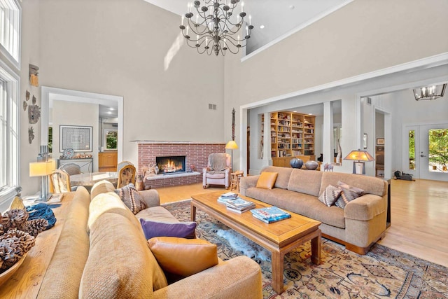 8673 Timber Ridge Dr, Burr Ridge, IL 60527 - living area with a chandelier, a high ceiling, a fireplace, and wood finished floors