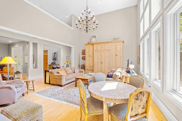 8673 Timber Ridge Dr, Burr Ridge, IL 60527 - dining area with a high ceiling, light wood-style flooring, a chandelier, and baseboards
