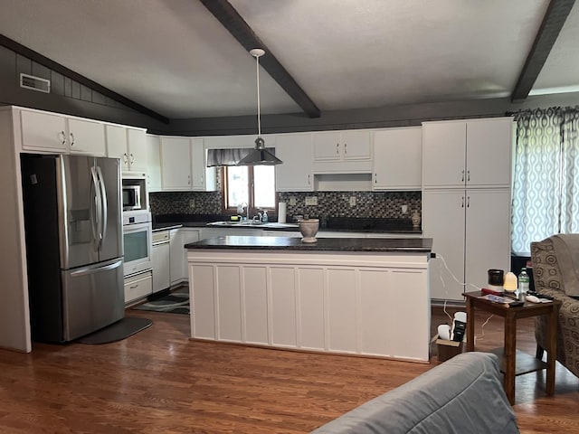 kitchen with dark countertops, a sink, visible vents, and stainless steel appliances