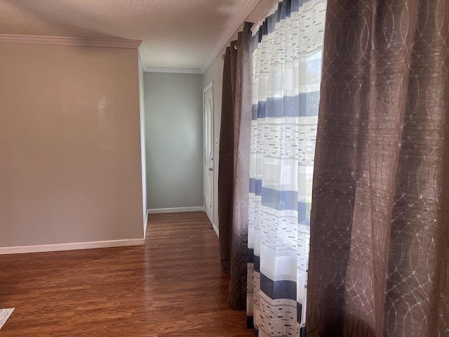 hallway featuring ornamental molding, baseboards, and wood finished floors