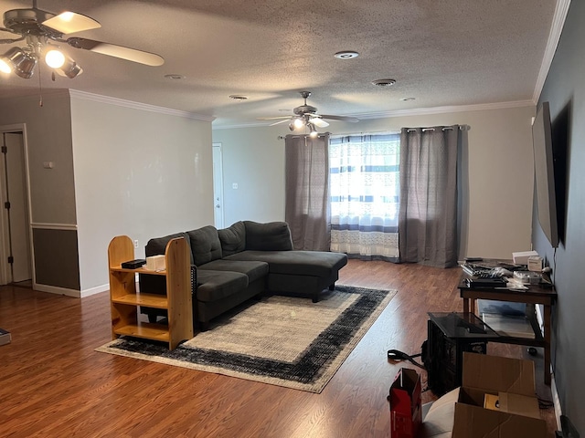 living area featuring a textured ceiling, wood finished floors, baseboards, and a ceiling fan
