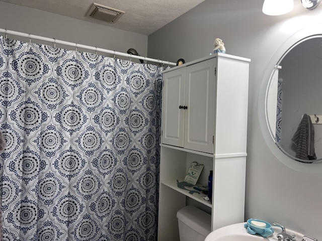 full bathroom featuring a sink, visible vents, toilet, and a shower with shower curtain