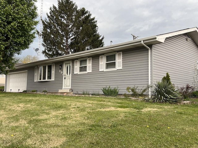 ranch-style home featuring a garage and a front lawn
