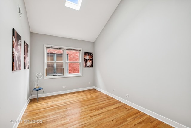 2336 W Harrison St Unit 4, Chicago, IL 60612 - spare room featuring a skylight, vaulted ceiling, baseboards, and wood finished floors