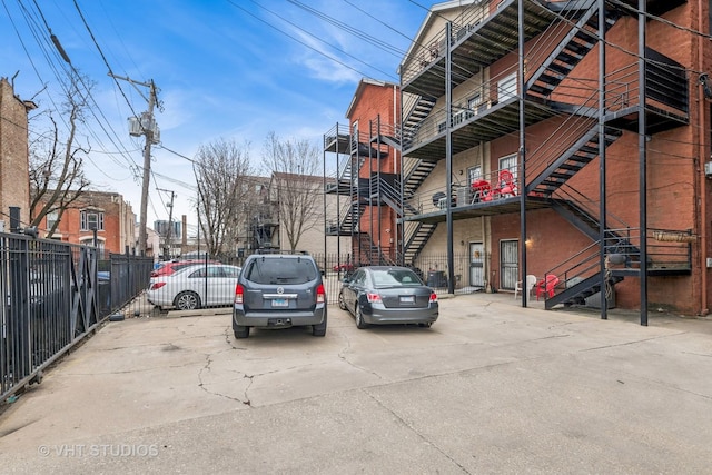 2336 W Harrison St Unit 4, Chicago, IL 60612 - view of property featuring stairs, fence, and uncovered parking